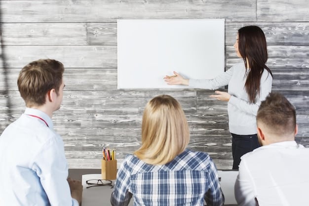 A classroom setting with students actively participating in a lesson using an interactive whiteboard. The students are standing around the whiteboard, pointing and gesturing at the content displayed on the screen. The ambiance is lively and engaged, indicating a collaborative learning environment.