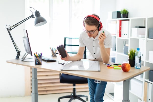 A student sitting at a desk, surrounded by notebooks, a laptop, and headphones, engaged in an activity that combines visual learning (looking at a diagram on screen), auditory (listening through headphones), and kinesthetic (highlighting notes).